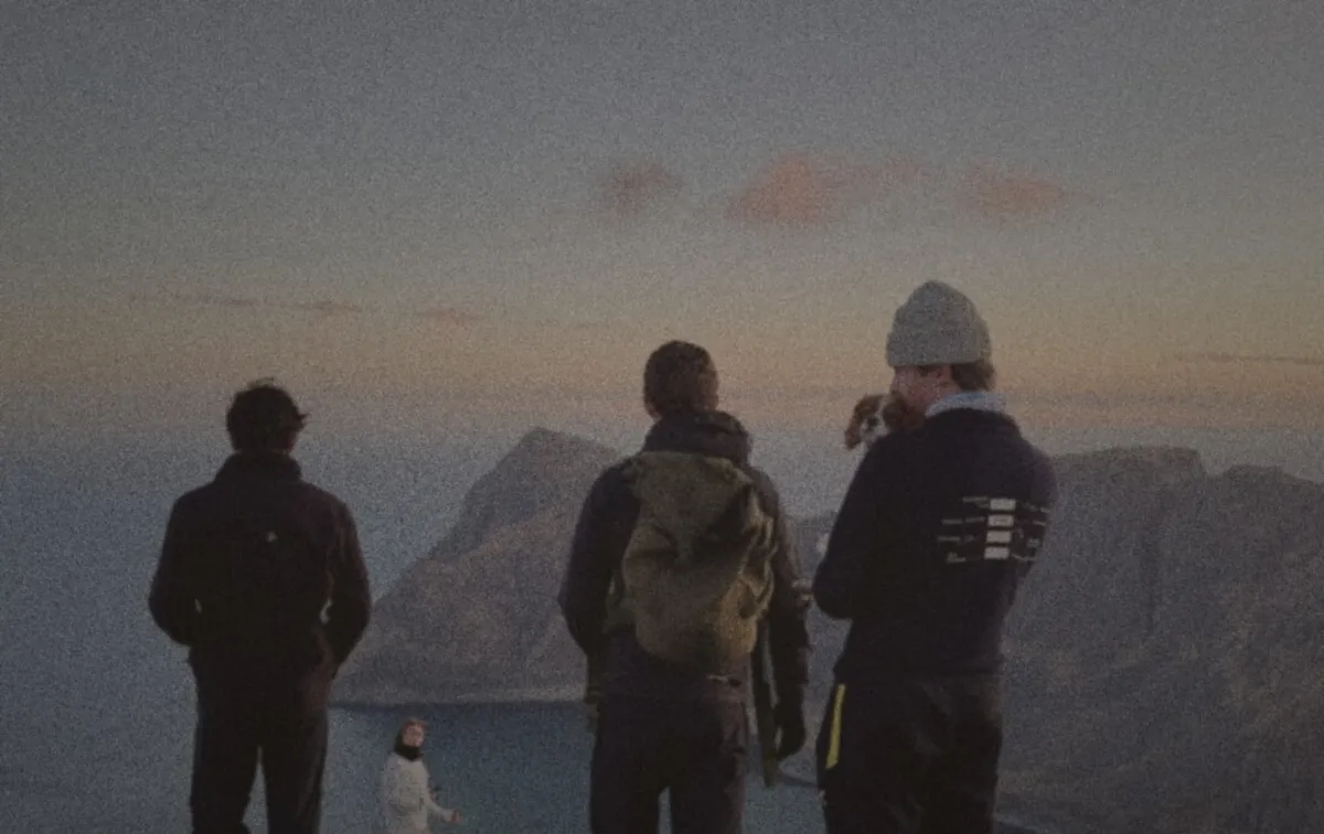 Calvin, Jack and Harry looking out over the sea from a mountain ridge at sunset